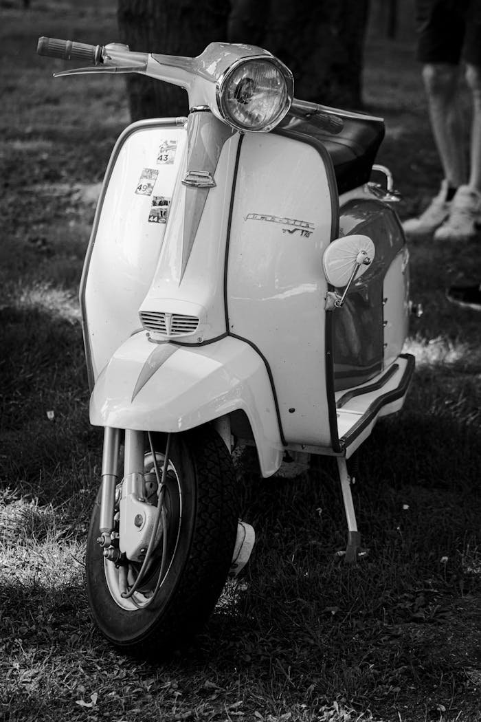 A vintage Vespa scooter captured in a stylish black and white close-up outdoors.